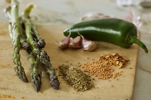 Ingredients for fermented asparagus: garlic, spices, jalapeno, and asparagus