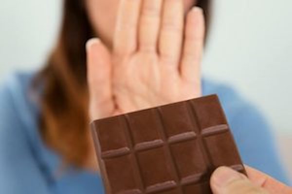 A women rejecting a chocolate bar to reduce high oxalate symptoms