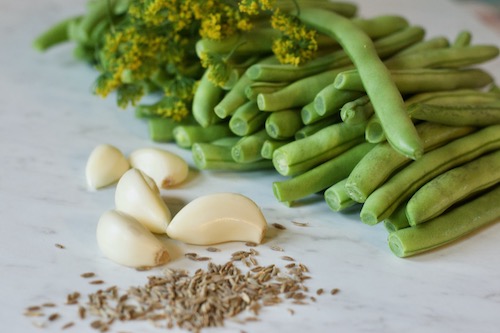 Ingredients for lacto-fermented green beans: cumin seeds, garlic cloves, dill head, and green beans